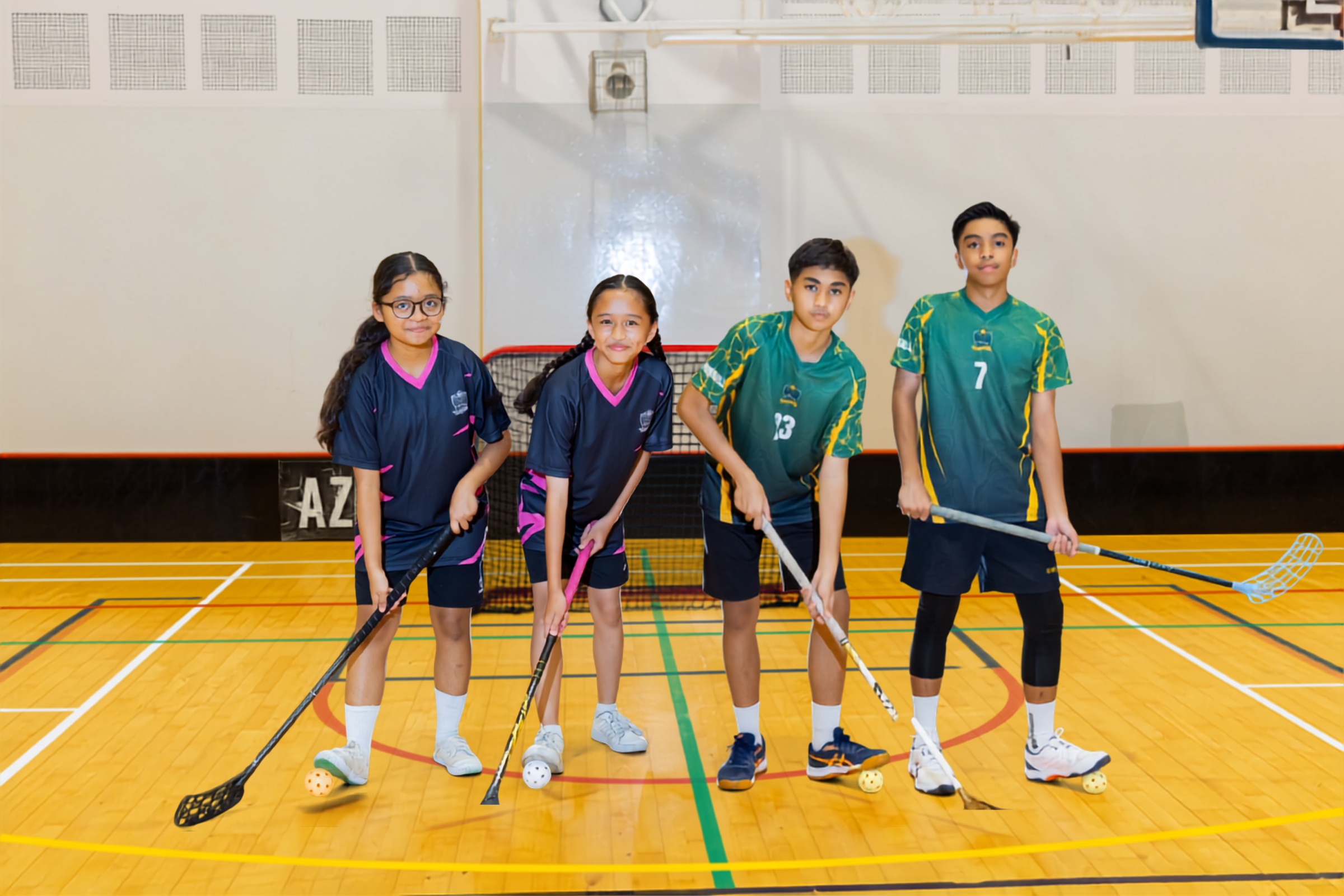 A combined banner photo featuring members of both the boys' and girls' floorball teams. The students are smiling and posing with their floorball sticks on a green outdoor sports court, wearing their respective team jerseys.